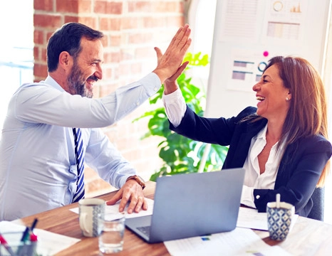 Smiling business professionals giving high five in office after successful meeting, teamwork and career growth concept
